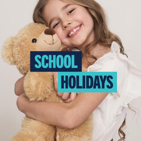Girl hugging a teddy bear. Text 'School Holidays'.