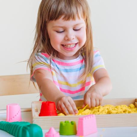 Little girl playing in play doh
